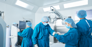 assistant-helping-surgeon-to-put-on-gloves-PWVTWTU